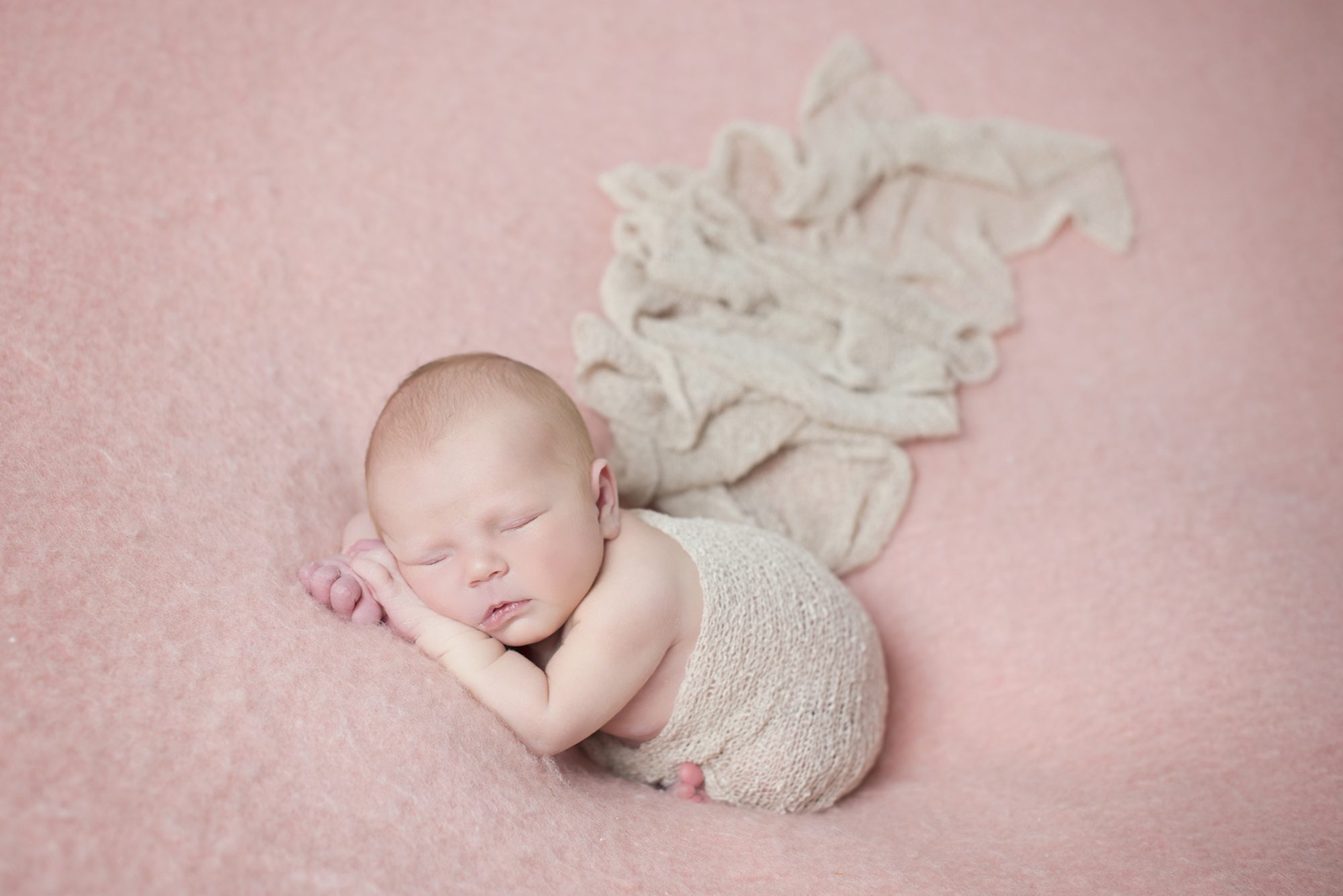 baby wrapped in cream on pink blanket by newborn photographer Woodley