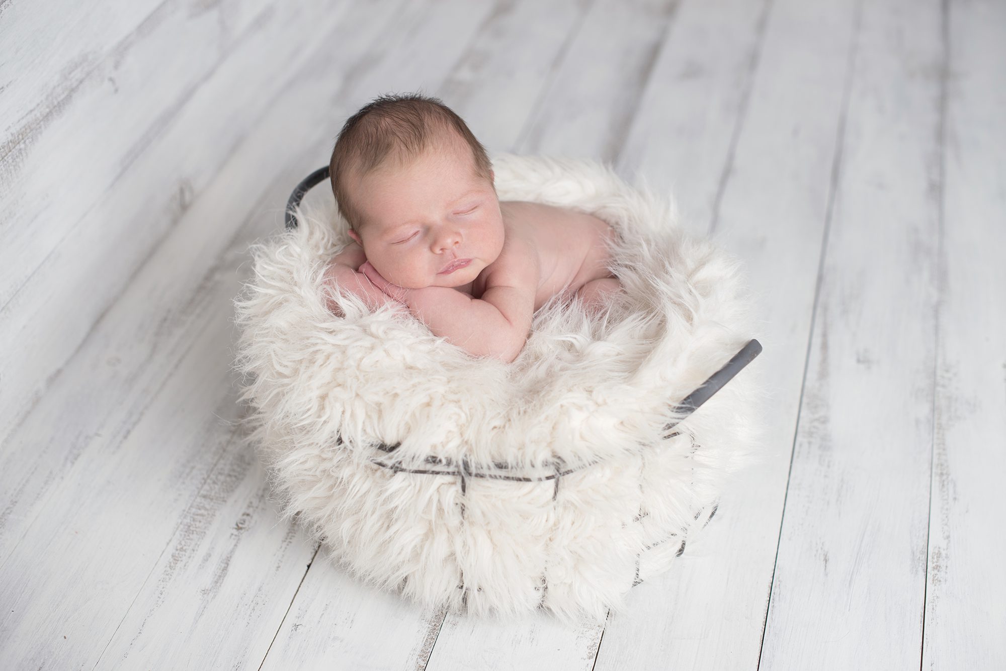 baby sleeping in basket in newborn photography session Wokingham