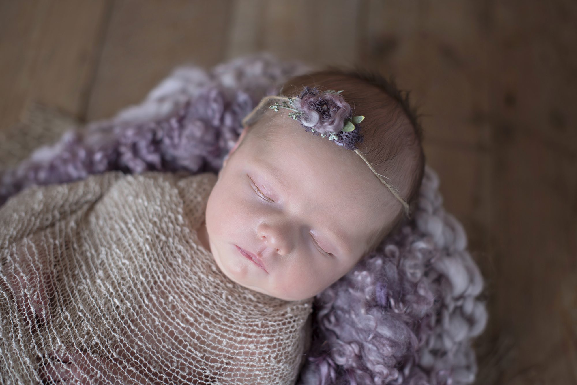 baby lying on purple blanket in newborn photography session Maidenhead
