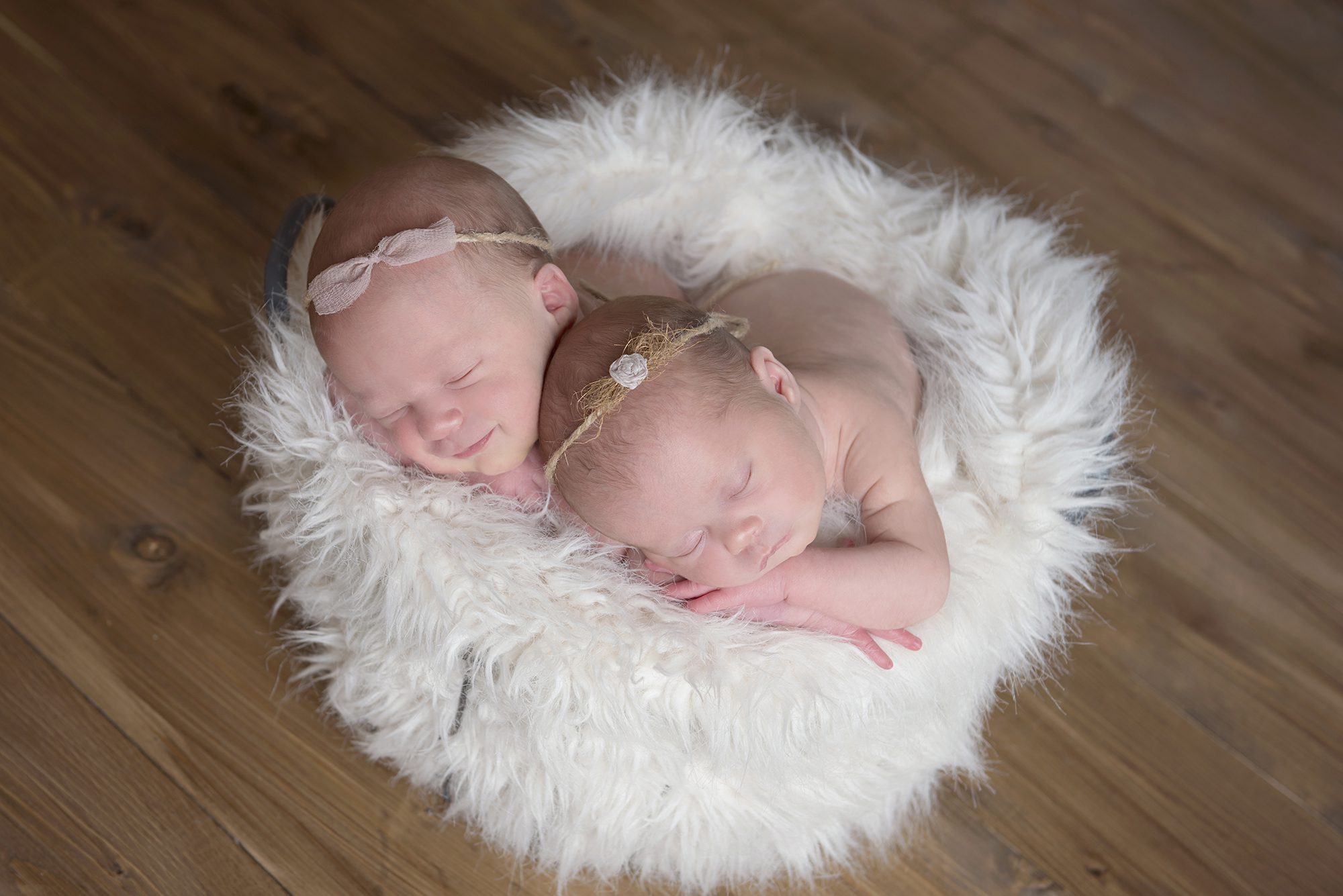 twin baby girls asleep on fur blanket in newborn photography session Reading