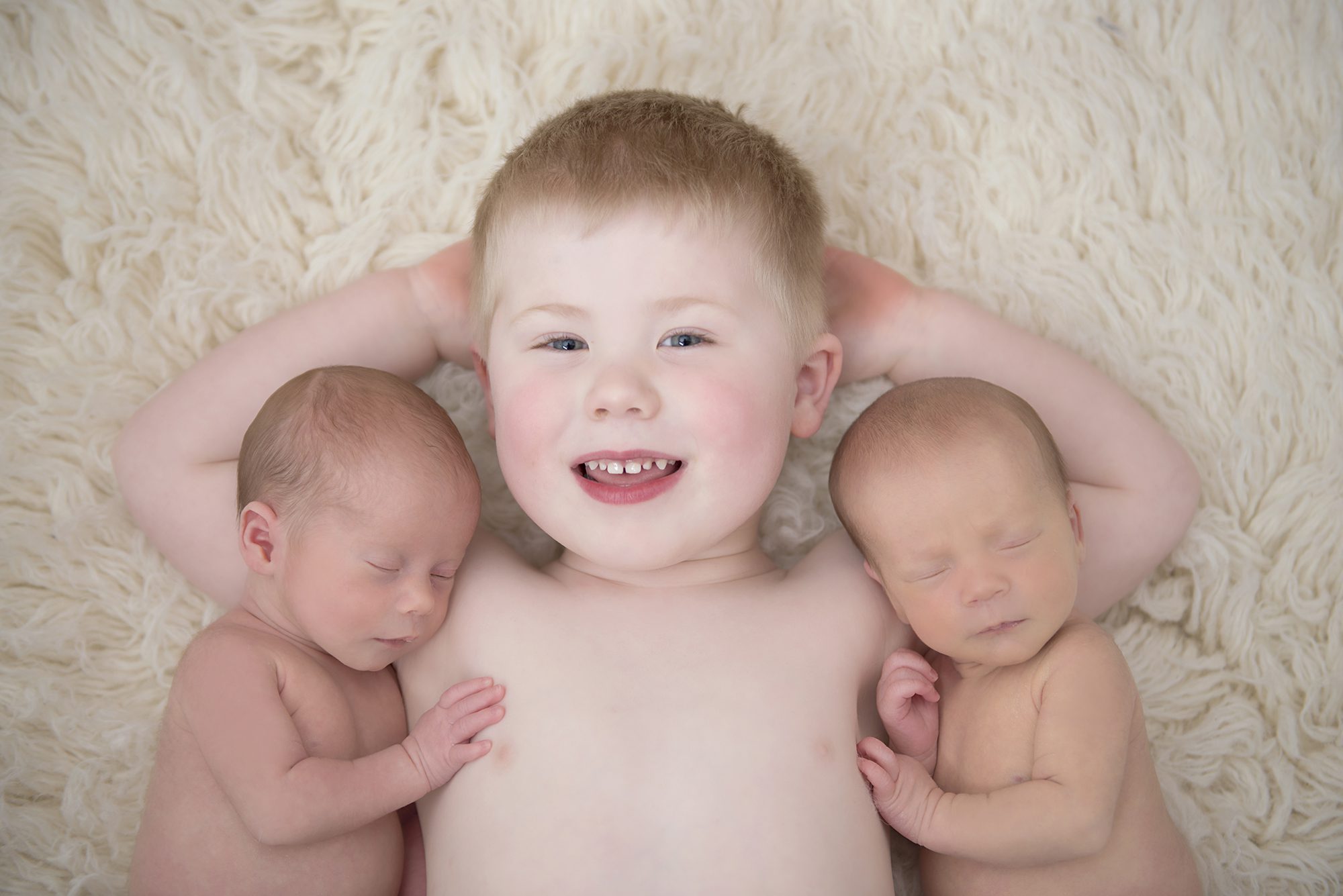 Big brother and baby twin sisters by newborn photographer Wokingham