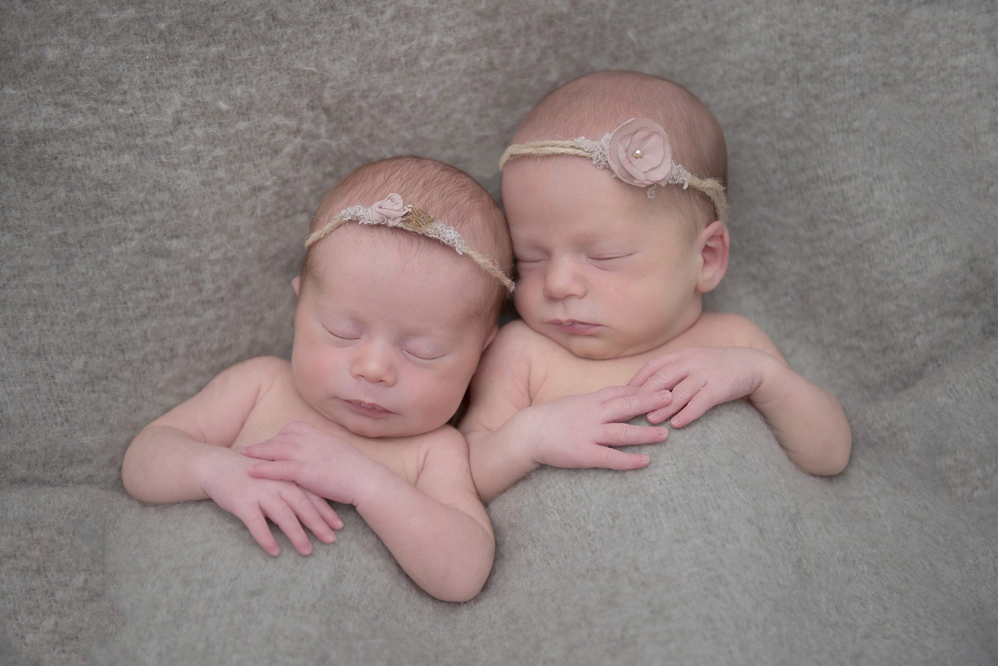 twin newborn girls sleeping on beige blanket in baby photoshoot Wokingham