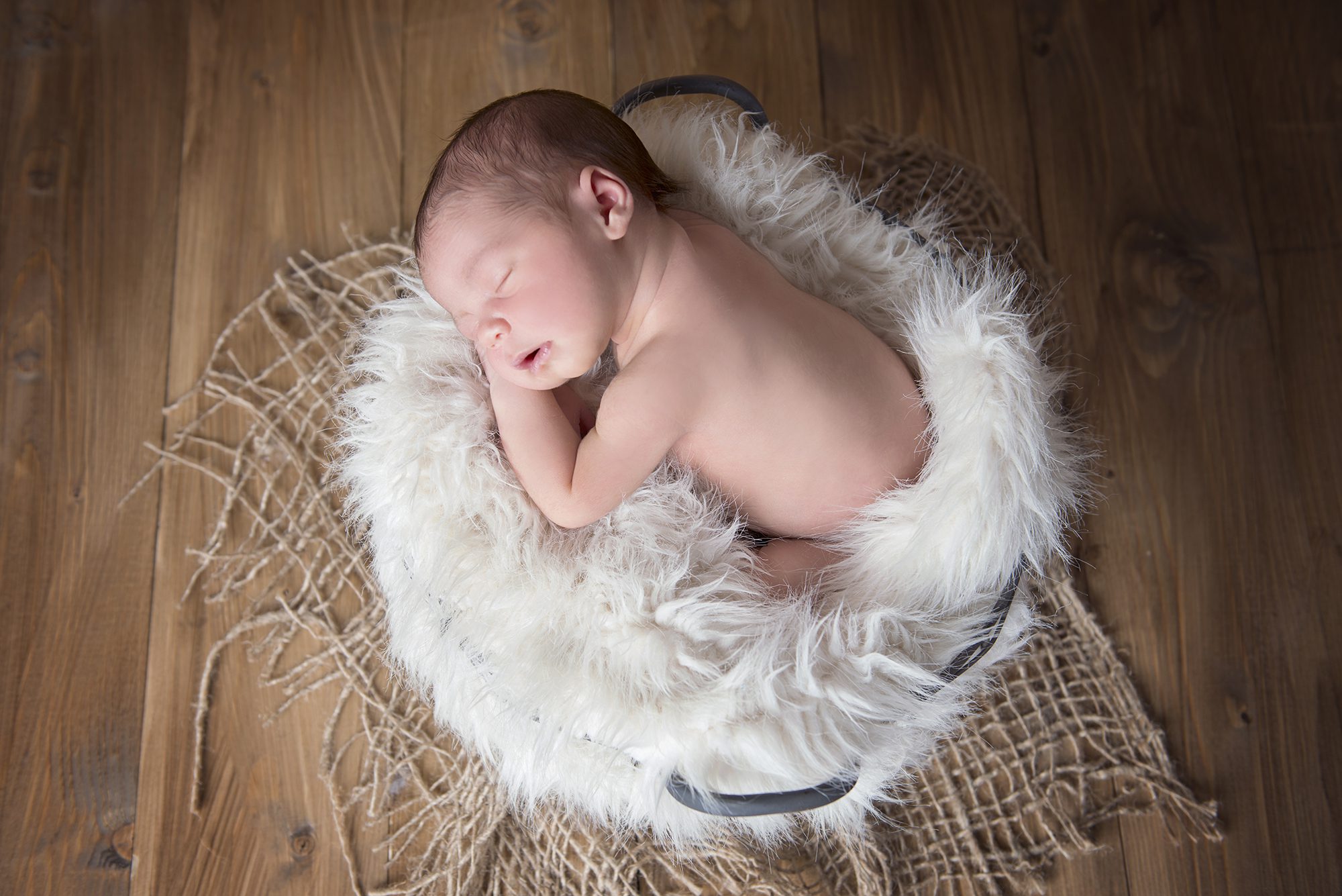 baby asleep in basket by newborn photographer Berkshire