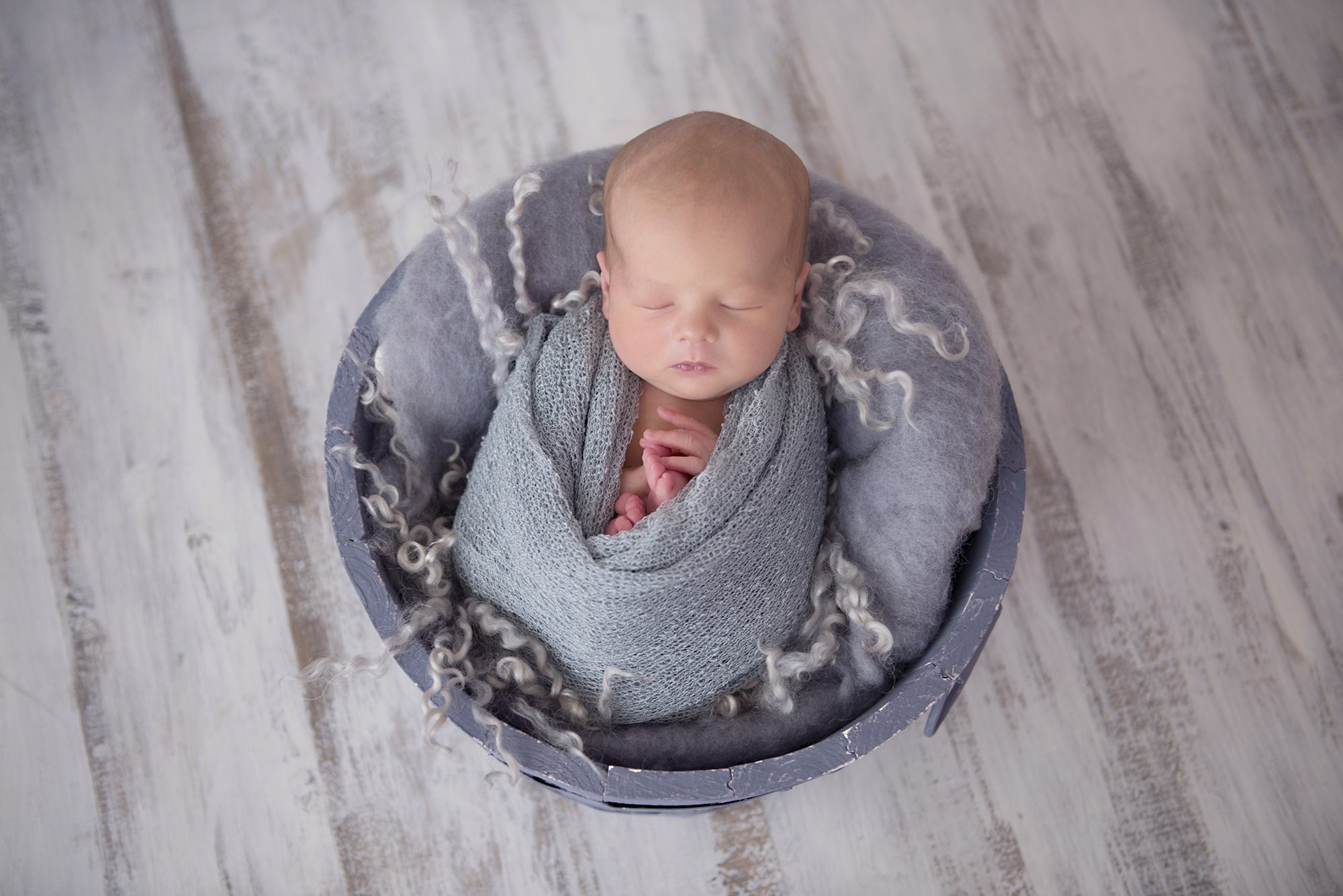 baby wrapped in blue for newborn photography session
