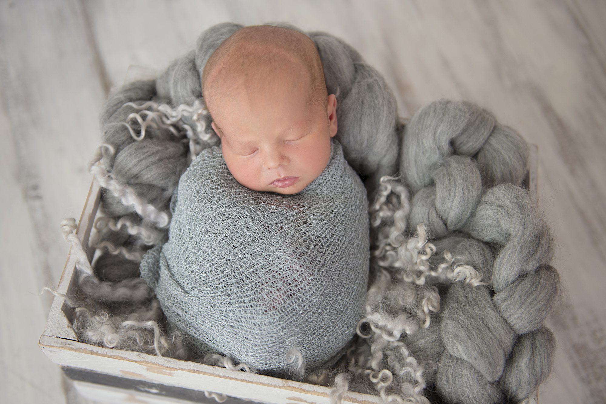 photo of baby boy wrapped in grey by newborn photographer Reading