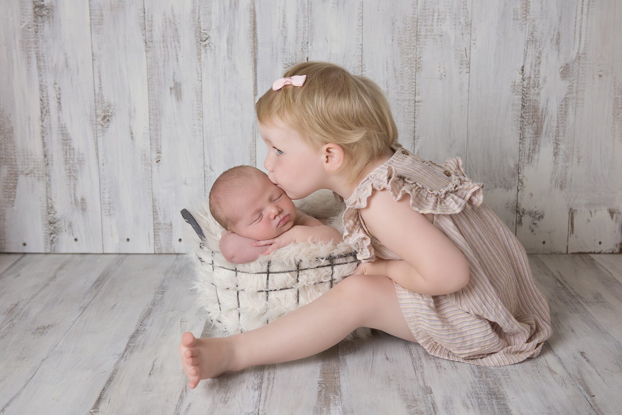little girl kissing baby brother for newborn photographer Wokingham