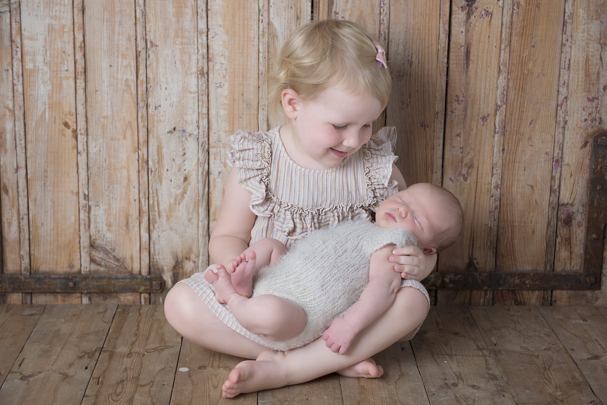 little girl holding baby brother photographed by newborn photographer Reading, Berkshire