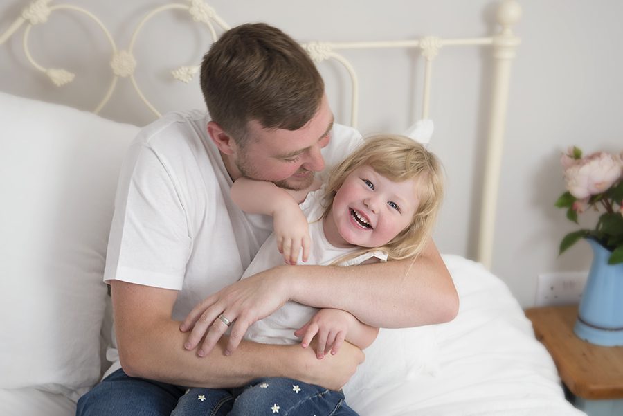 dad and daughter laughing by family photographer Berkshire, Reading