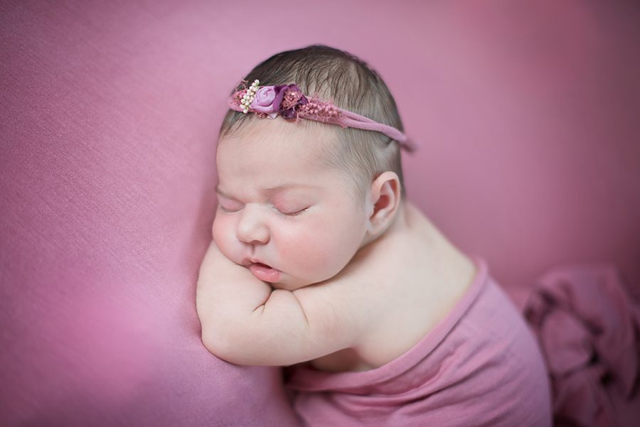 newborn baby asleep on purple background by photographer in Berkshire
